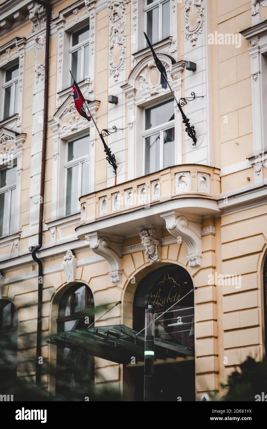 Colpo stretto sul vecchio edificio storico con balcone nel mezzo e bandiere della Slovacchia e Unione europea sopra a luce nuvolosa morbida Foto Stock