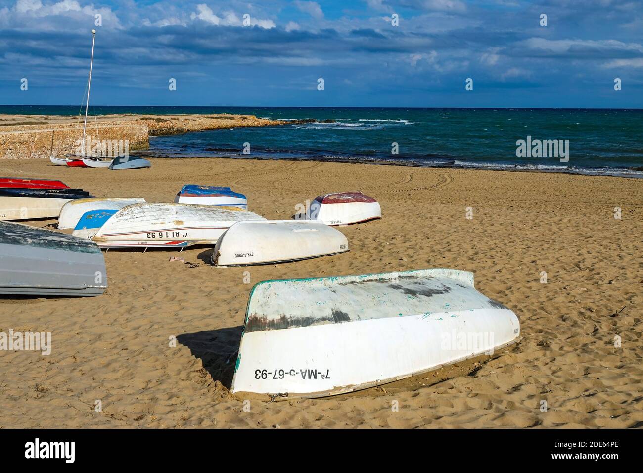 Piccole barche capovolta sulla spiaggia di la Mata, Torrevieja, Costa Blanca, Spagna, provincia di Valencia Foto Stock