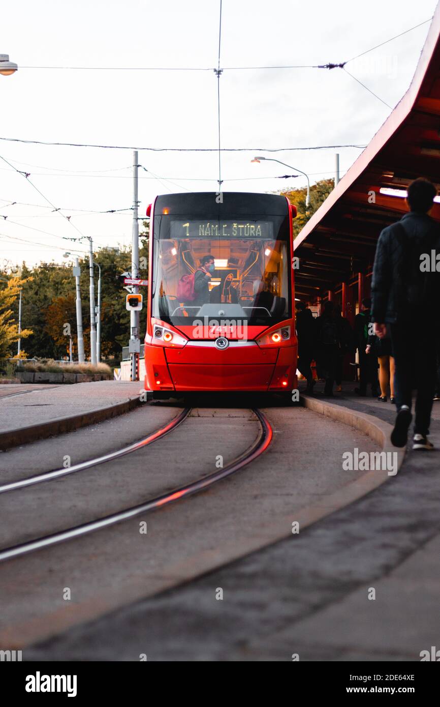 Vista frontale sul tram che aspetta la fermata del tram per le persone Per entrare all'alba a Bratislava Foto Stock