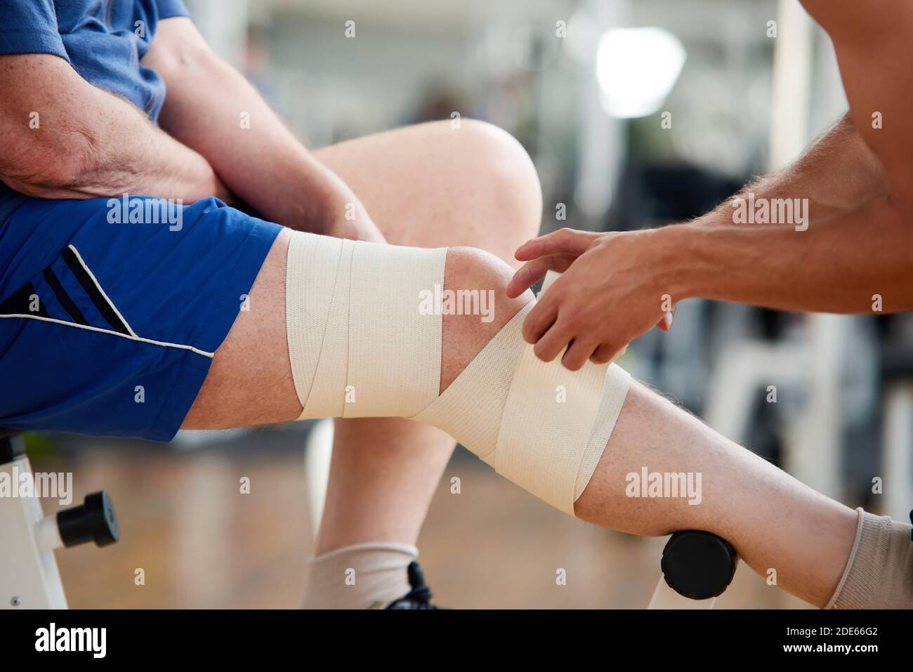 Primo piano mani che avvolgono il bendaggio sulla gamba maschile in  palestra Foto stock - Alamy