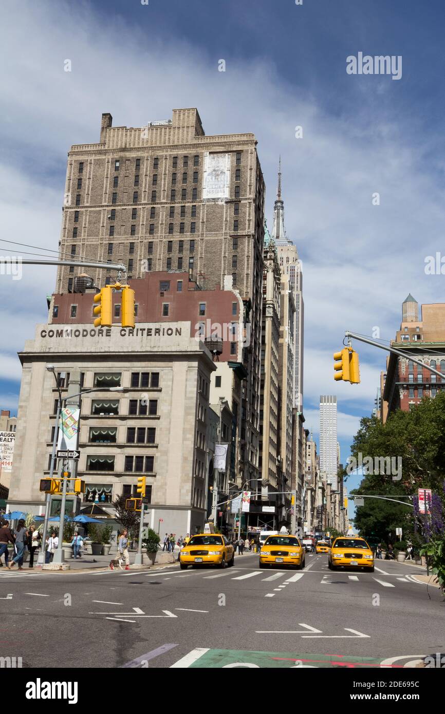 I taxi gialli si fermavano al semaforo con l'Empire state Building sullo sfondo, New York, USA Foto Stock