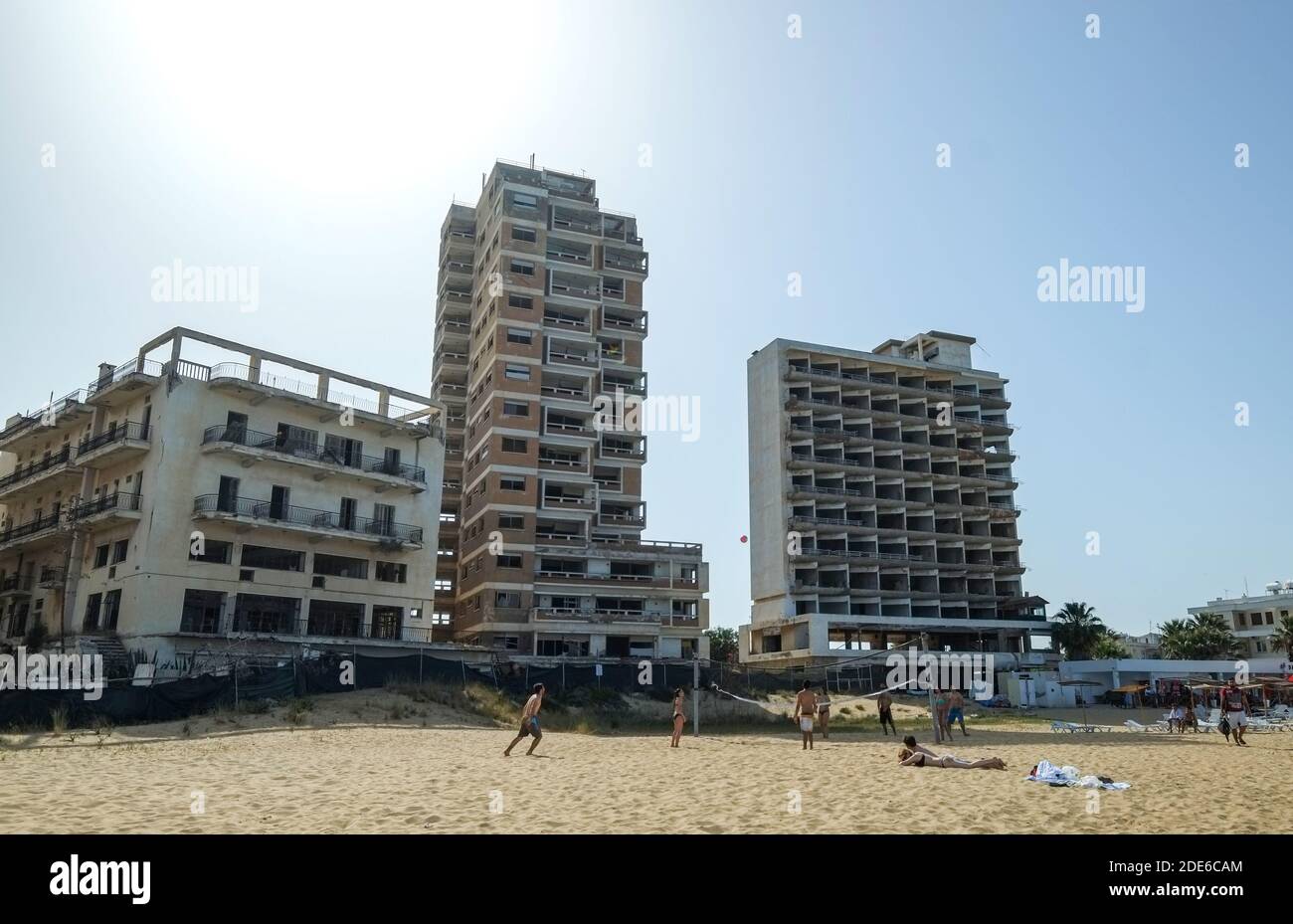 Varosha, Cipro. I turisti giocano sulla spiaggia di fronte agli hotel abbandonati a Varosha, Famagosta, ora parte della Cipro settentrionale occupata dai turchi (TRNC). Foto Stock