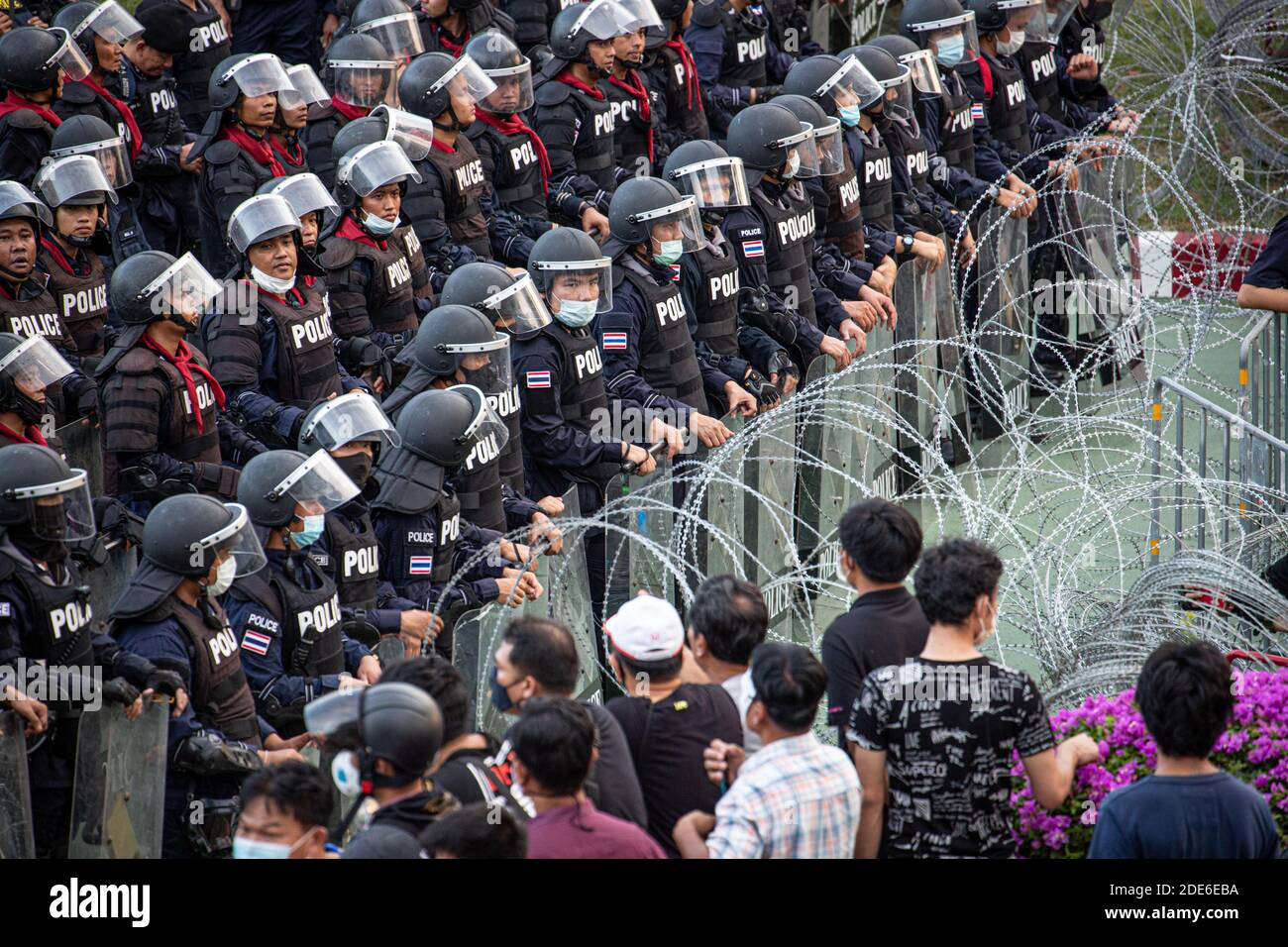 Bangkok, Thailandia. 29 Nov 2020. La polizia riota si trova dietro i fili spannocchiati durante una manifestazione anti-governativa nella capitale tailandese. Migliaia di manifestanti a favore della democrazia si sono riuniti fuori dall'11° Reggimento della fanteria chiedendo le dimissioni del primo Ministro thailandese e la riforma della monarchia. Credit: SOPA Images Limited/Alamy Live News Foto Stock