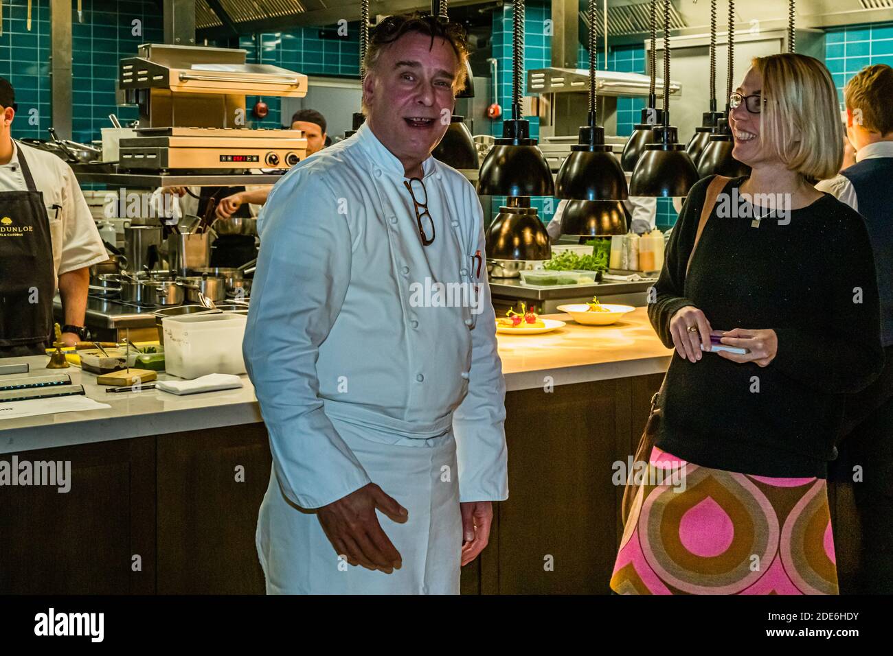 Chef Jupp Osterloh di fronte alla nuova cucina a vista del ristorante Grill in conversazione con Angela Berg. Dunloe Hotel vicino Killarney, Irlanda Foto Stock