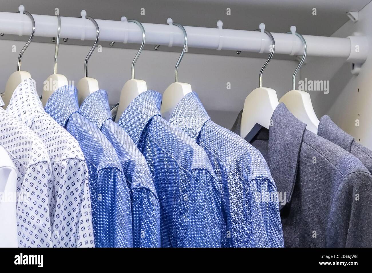 le camicie degli uomini sono appese nell'armadio Foto stock - Alamy