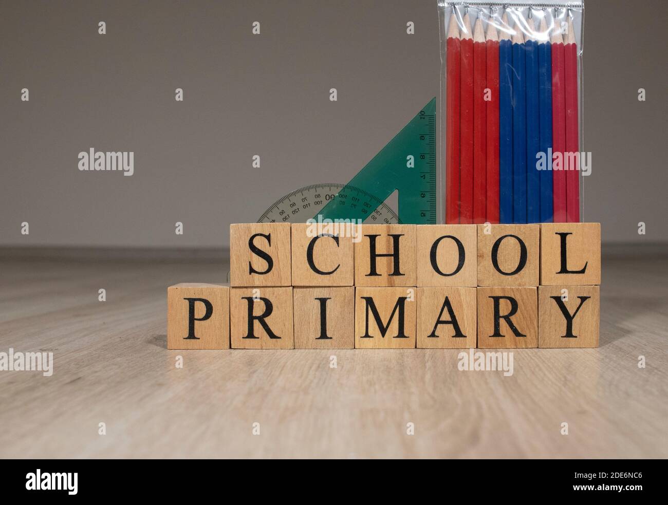 parola lunga primaria da lettere piccole di legno grigio con nero carattere su sfondo arancione Foto Stock