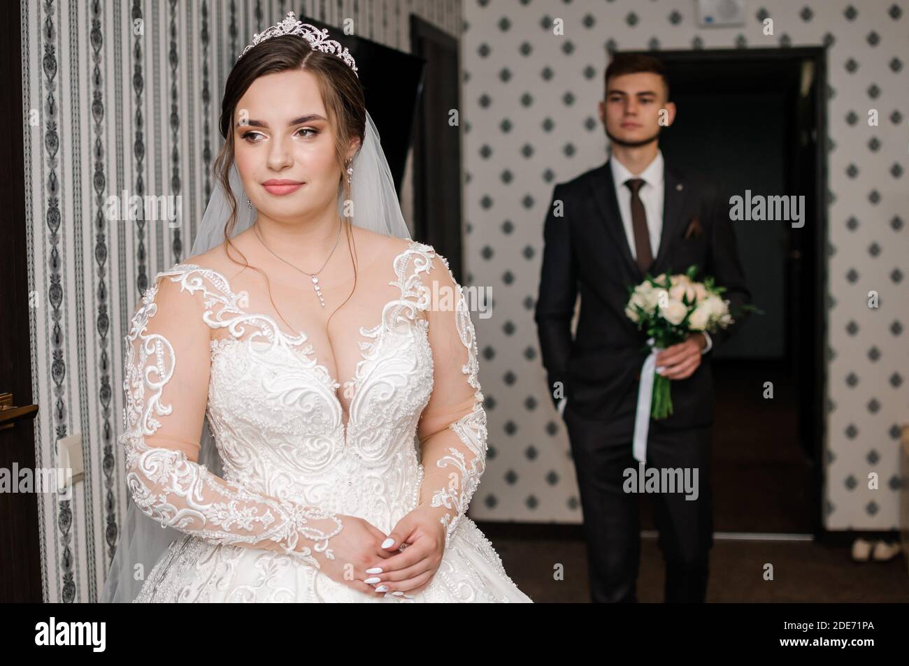 lo sposo incontra la sposa e dà un bouquet di fiori in camera Foto Stock