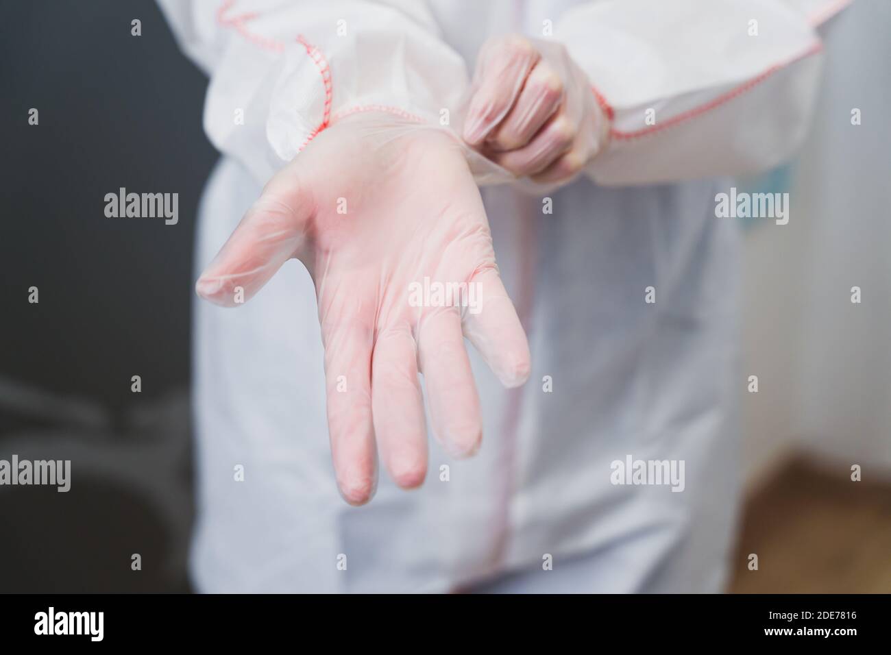 Medico che indossa guanti in lattice per evitare il contagio da parte del virus covid 19, primo piano Foto Stock