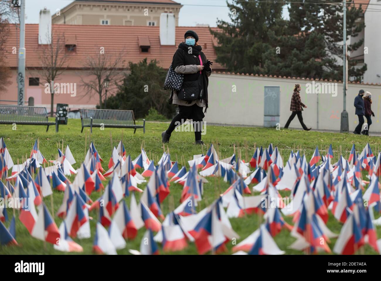Donna che indossa una maschera facciale cammina per tributo alle vittime del coronavirus. Ogni vittima di Coronavirus è rappresentata da una bandiera nazionale della Repubblica Ceca. A partire da oggi più di 8000 persone sono morte a causa della pandemia di Coronavirus di Covid19 nella Repubblica Ceca. Foto Stock