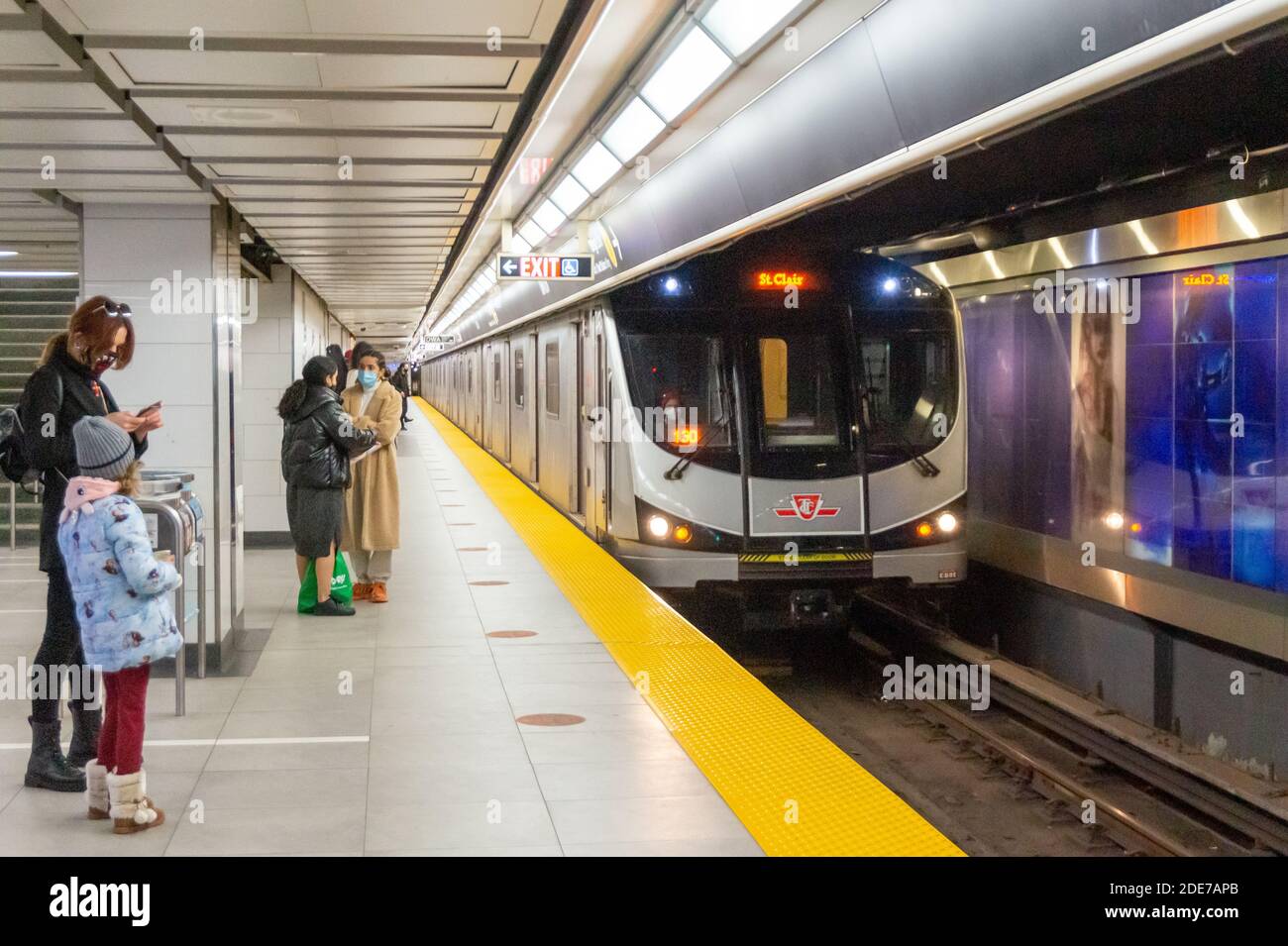 Persone che indossano maschere facciali di protezione nella piattaforma metropolitana sotterranea appartenente alla Toronto Transit Commission o TTC. È il tempo dei Covi Foto Stock
