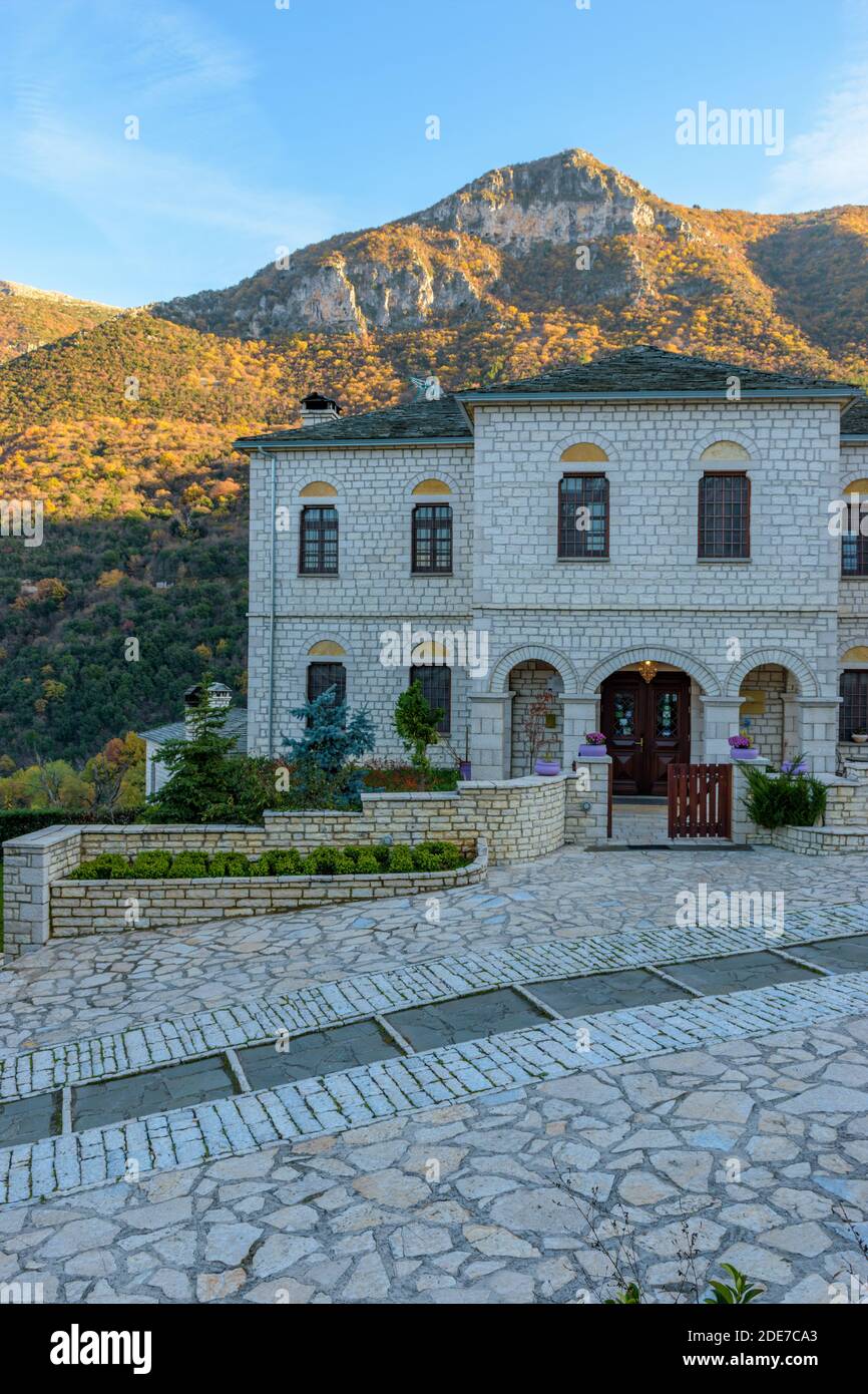 Tradizionale edificio in pietra con montagna astraka come sfondo durante la stagione autunnale nel pittoresco villaggio di Aristi in Zagori Grecia. Foto Stock