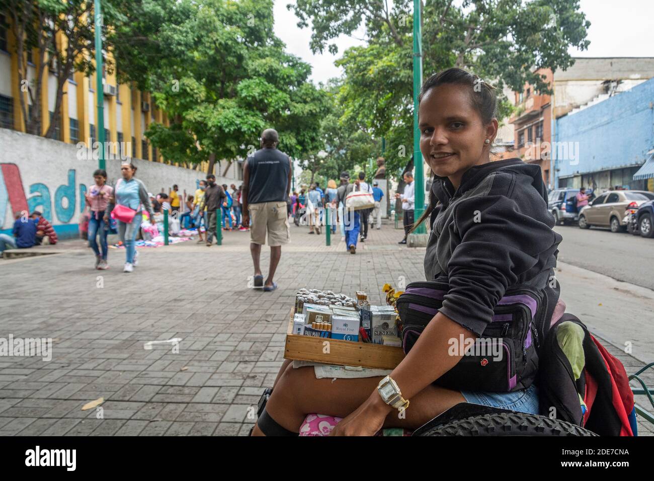 Eunice Valecillos (32) vende sigari dettagliati dalla sua sedia a rotelle, come supporto vitale. Era su un altro viale, Sabana Grande, ma a causa di Th Foto Stock