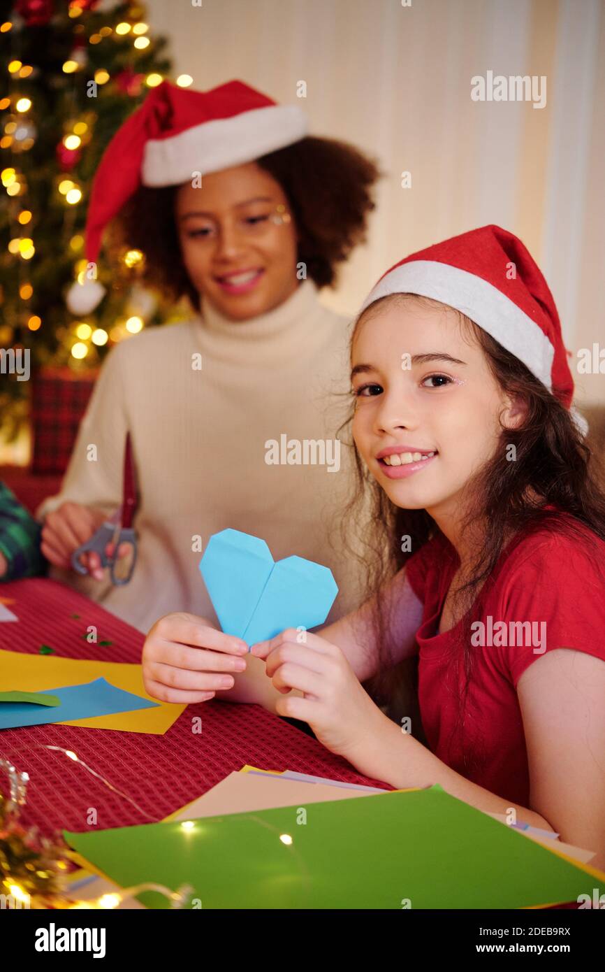 Ragazza che fa carta cuore Foto Stock