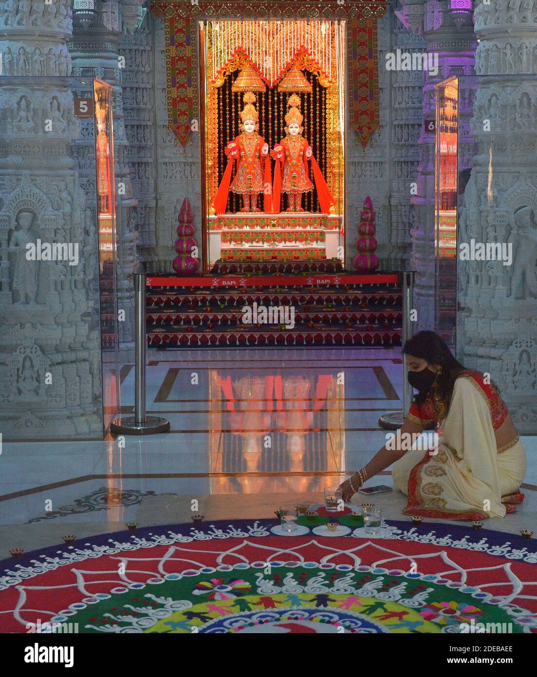 Una donna tende un'opera di arte della sabbia conosciuta come rangoli prima delle celebrazioni di Diwali al MANDIR Swaminarayan di BAPS, un grande tempio indù a Chino Hills, California, sabato 14 novembre 2020. Diwali, il festival indiano della luce, celebra la sconfitta dell'ignoranza attraverso la conoscenza da parte di un miliardo di persone in tutto il mondo. Il vice presidente eletto Kamala Harris, che sarà il primo VP sudasiatico americano, ha twittato fuori gli auguri per un Diwali felice. Foto di Jim Ruymen/UPI Foto Stock