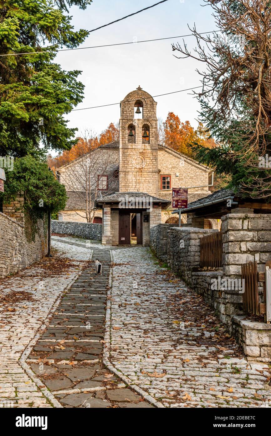 Architettura tradizionale con stretta strada in pietra e pietra di Agios Athanasios Costruita la chiesa durante la stagione autunnale nel villaggio di pietra Monodendri centro Foto Stock Architettura tradizionale con stretta strada in pietra e pietra di Agios Athanasios Costruita la chiesa durante la stagione autunnale nel villaggio di pietra Monodendri centro Foto Stock