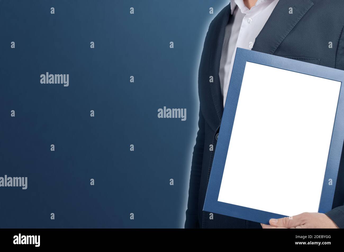 mockup uomo d'affari che tiene il diploma cornice su sfondo blu. uomo che tiene vuoto immagine certificato di graduazione cornice. Dipendente con segno vuoto. Copyspa Foto Stock