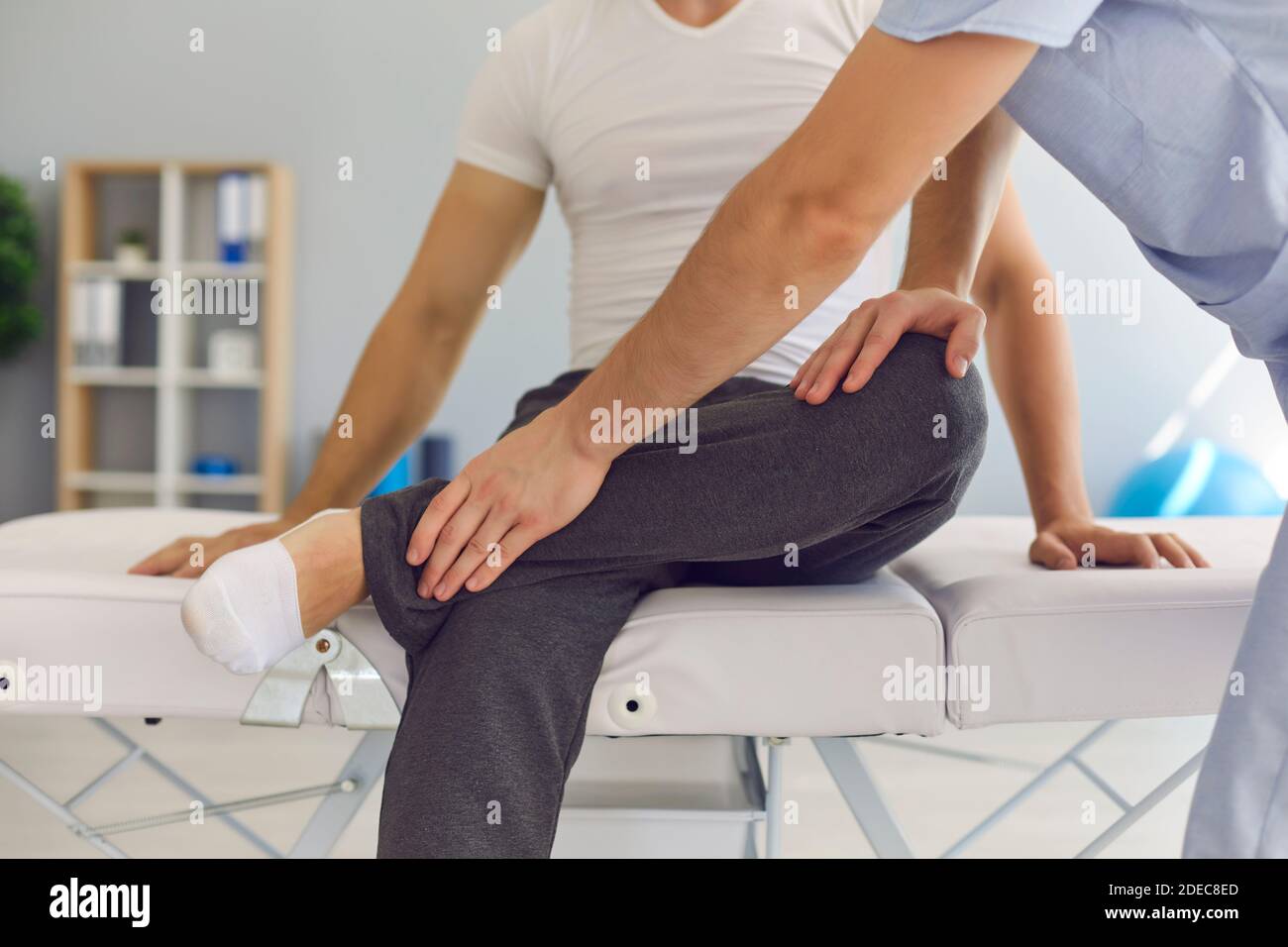 Primo piano di atleta maschile che riceve assistenza professionale in centro medico dopo lesioni sportive. Foto Stock