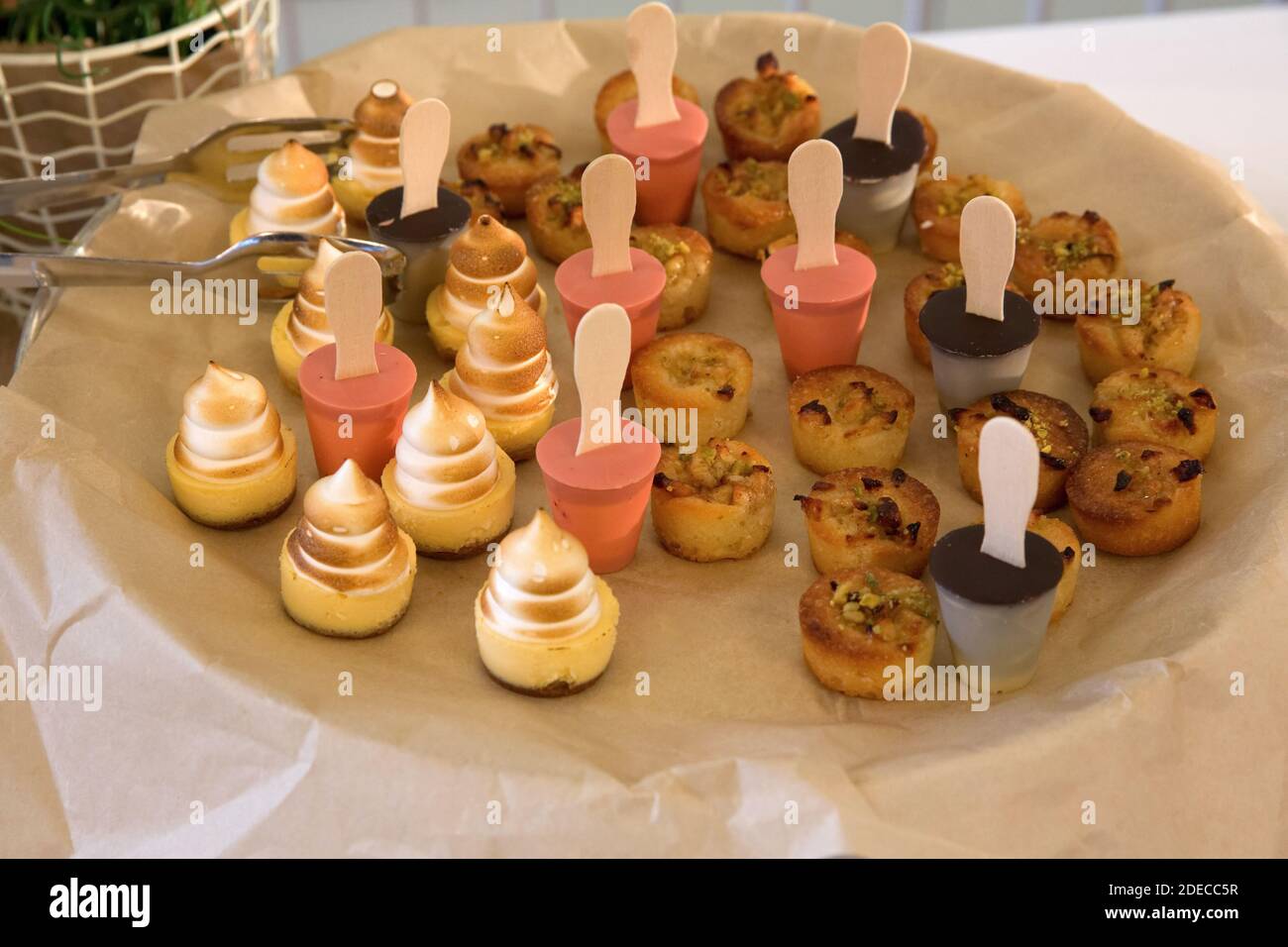 Un tavolo a buffet carico di cibo. Un piatto da dessert di tartelette dolci (piccole crostate con vari ripieni dolci) Foto Stock