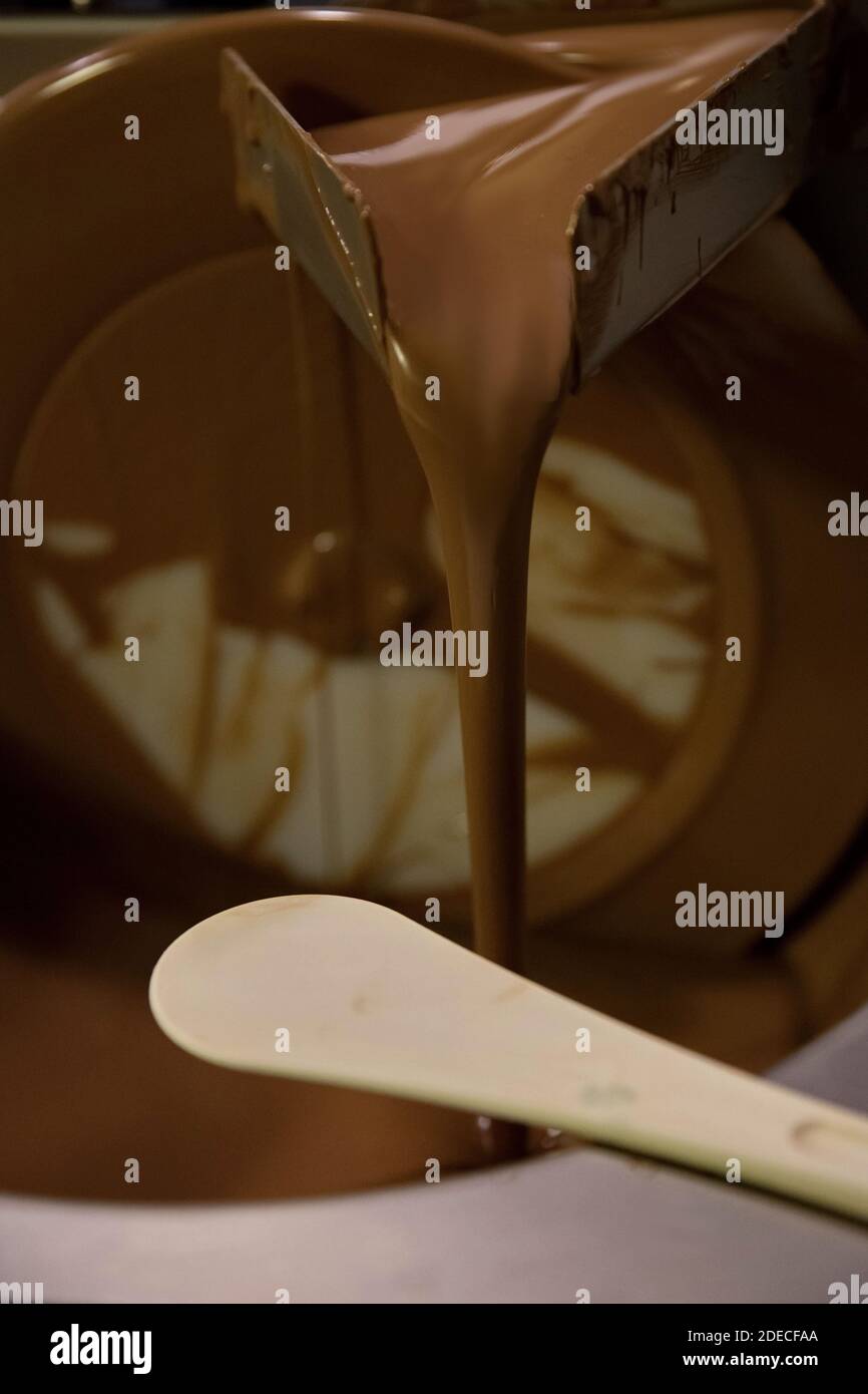 Mescolando e mescolando il cioccolato fondente con un cioccolatiere artigianale Foto Stock