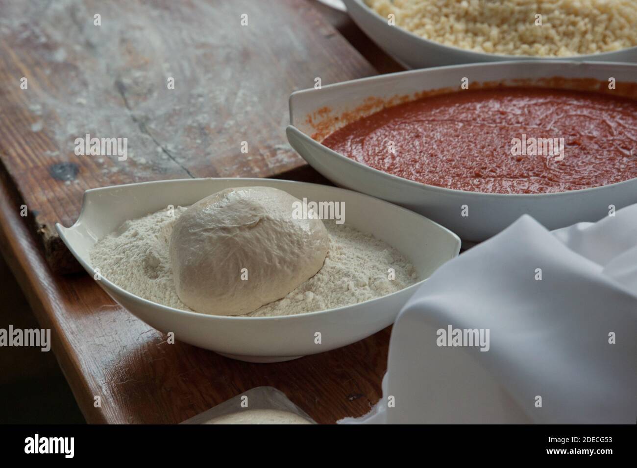 Preparazione e cottura di una focaccia pizza con purea di pomodoro e. formaggio Foto Stock
