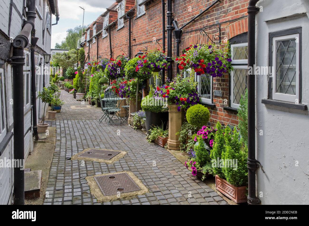Turks Head Court, Eton, Berkshire, UK; cortile colorato con piante di container e cestini appesi. Foto Stock