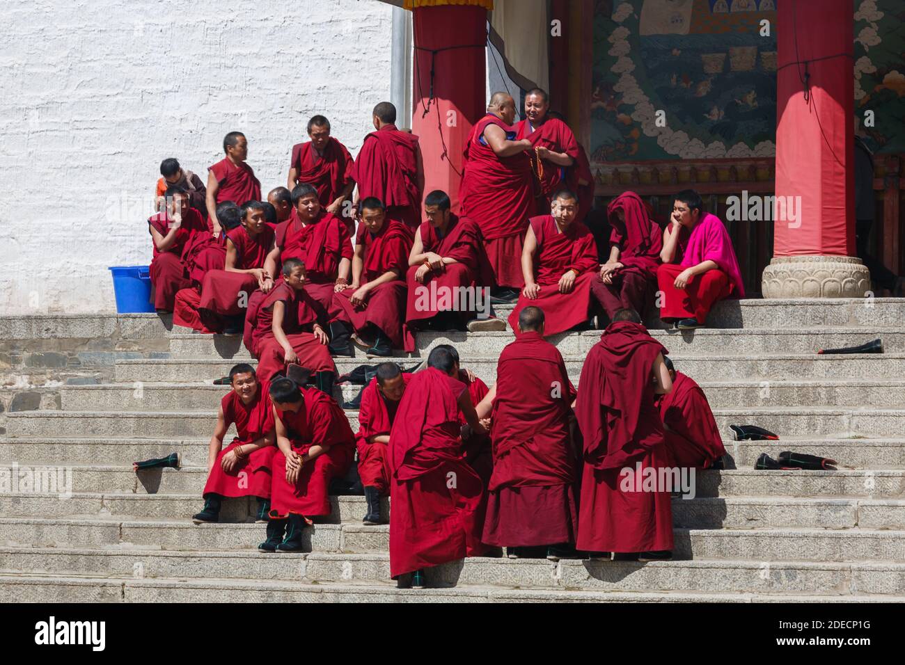 Xiahe, Provincia di Gansu / Cina - 28 aprile 2017: I monaci tibetani dell'Ordine Gelug si riuniscono alle scale di un edificio al Monastero di Labrang. Alcuni sitt Foto Stock