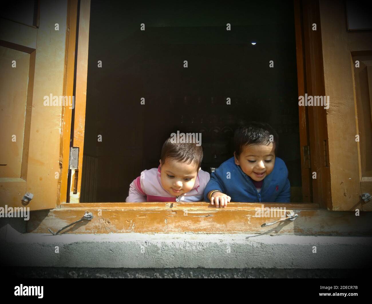 India 02 luglio 2020 13 agosto 2018 Kupwara città Jammu e Kashmir . Due bambini che osservano attraverso lo sfondo della finestra di colore dorato è nero Foto Stock