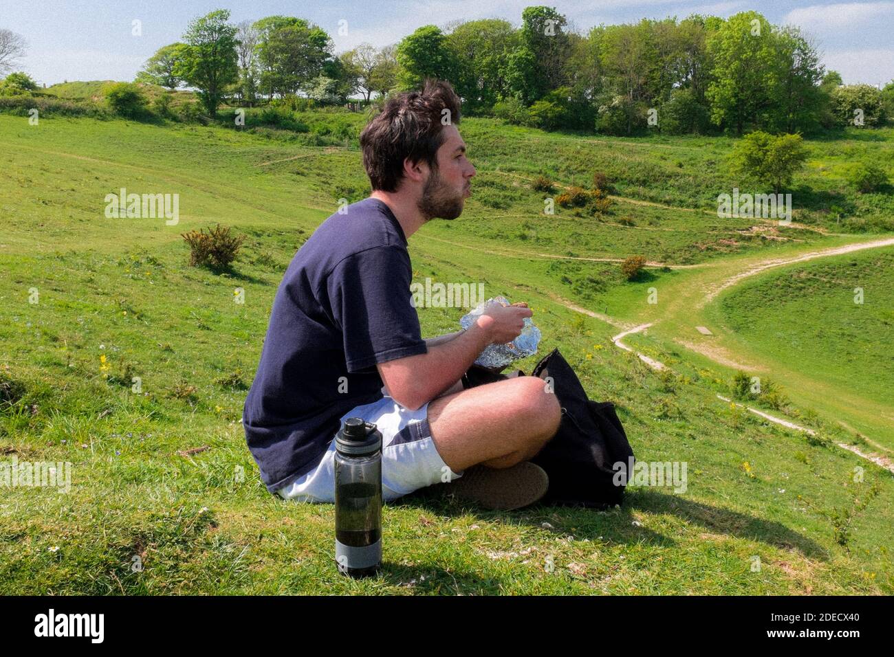 Giovane uomo che mangia al Devils Dyke appena fuori da Brighton & Hove, East Sussex, Regno Unito Foto Stock