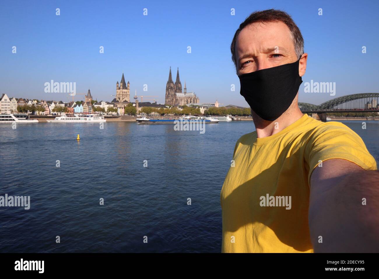 Selfie turistico con maschera facciale a Colonia città, Germania. Selfie dei viaggiatori con lo skyline di Colonia. Foto Stock