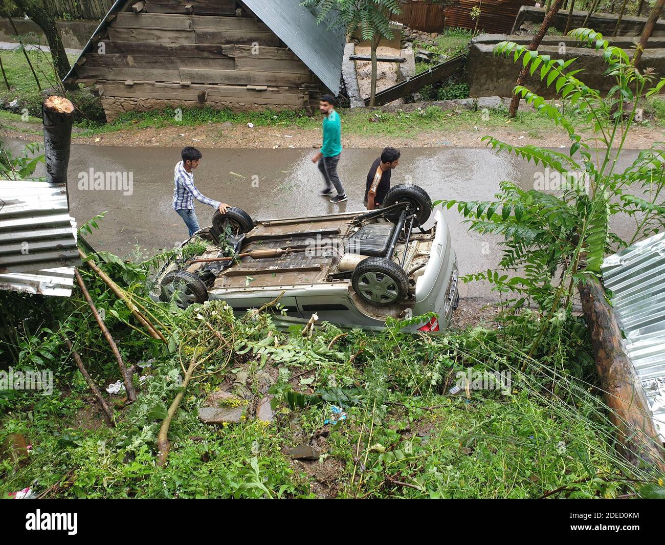 India 03 giugno 2020 incidente automobilistico nel distretto di kupwara in maggio 2019 durante le cadute di pioggia tre persone sono in piedi lungo lato sulla strada una piccola casa è b Foto Stock