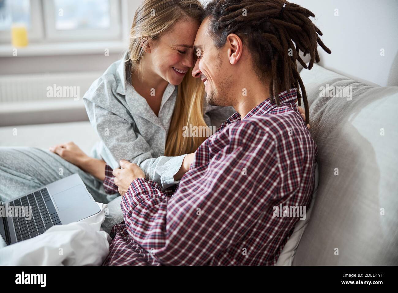 Felice giovane coppia che tocca le fronte a casa Foto Stock