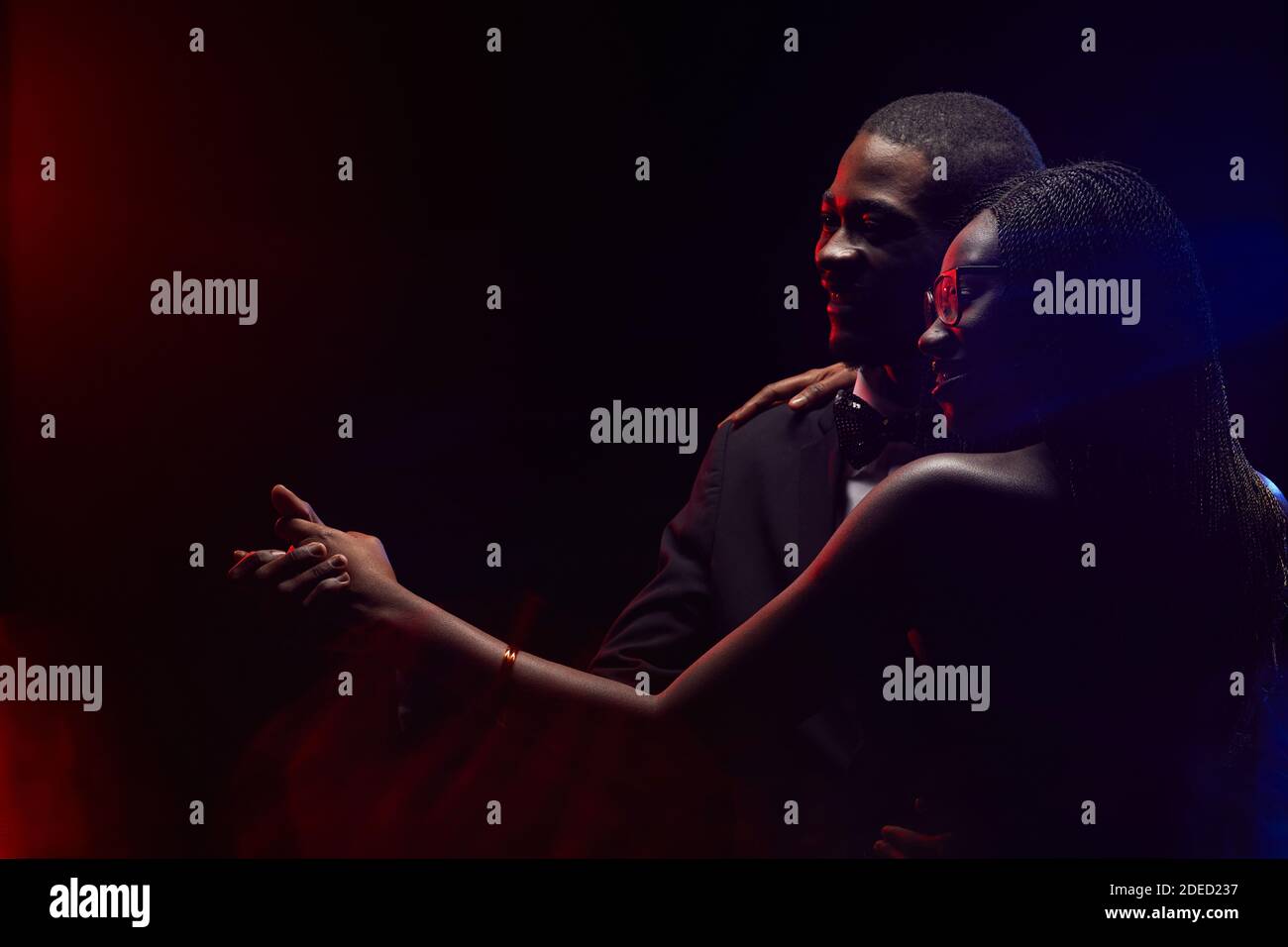 Profilo di elegante coppia afro-americana che rallenta insieme in buio, spazio di copia Foto Stock