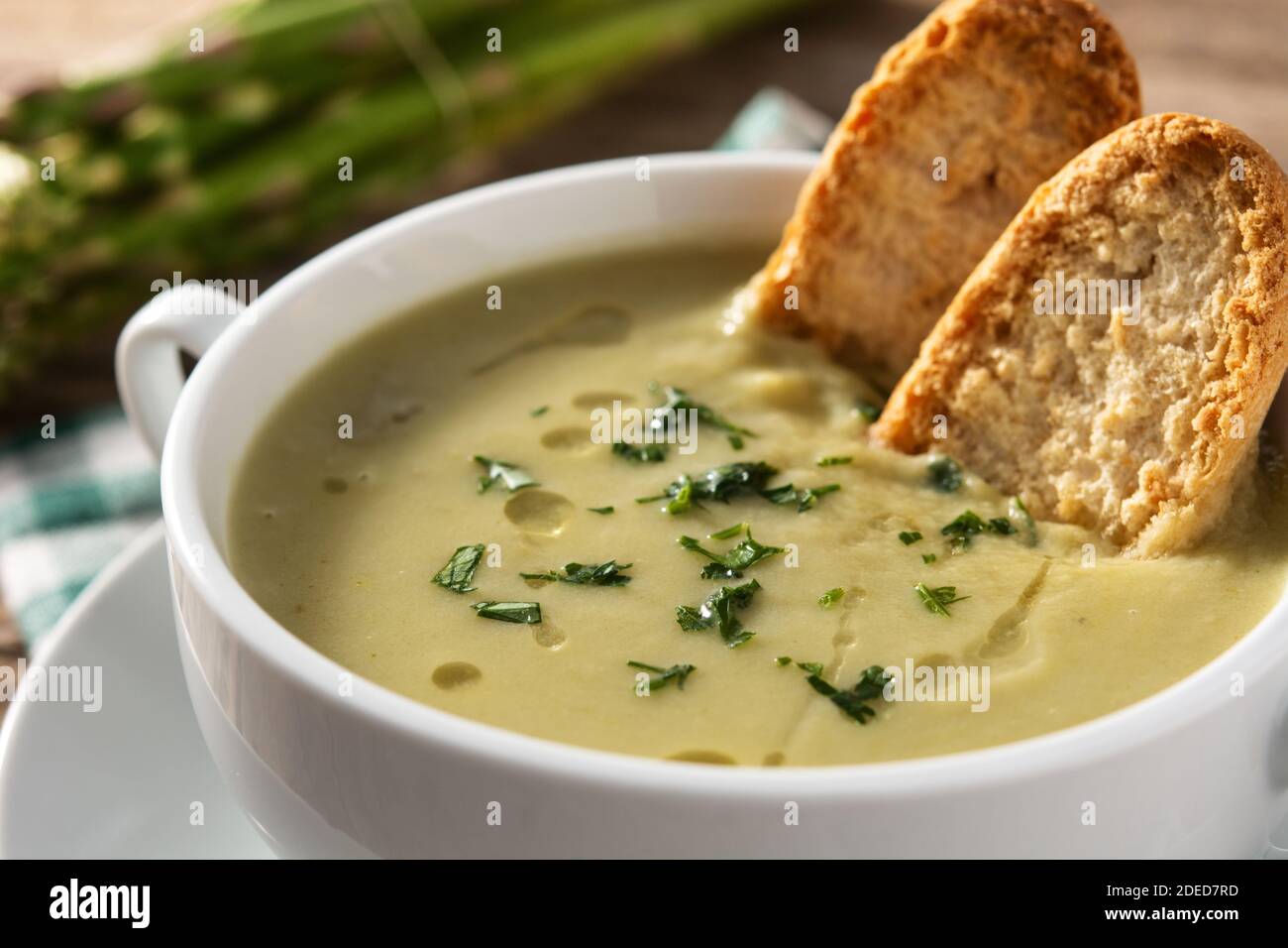 Zuppa di asparagi freschi su tavola di legno Foto Stock