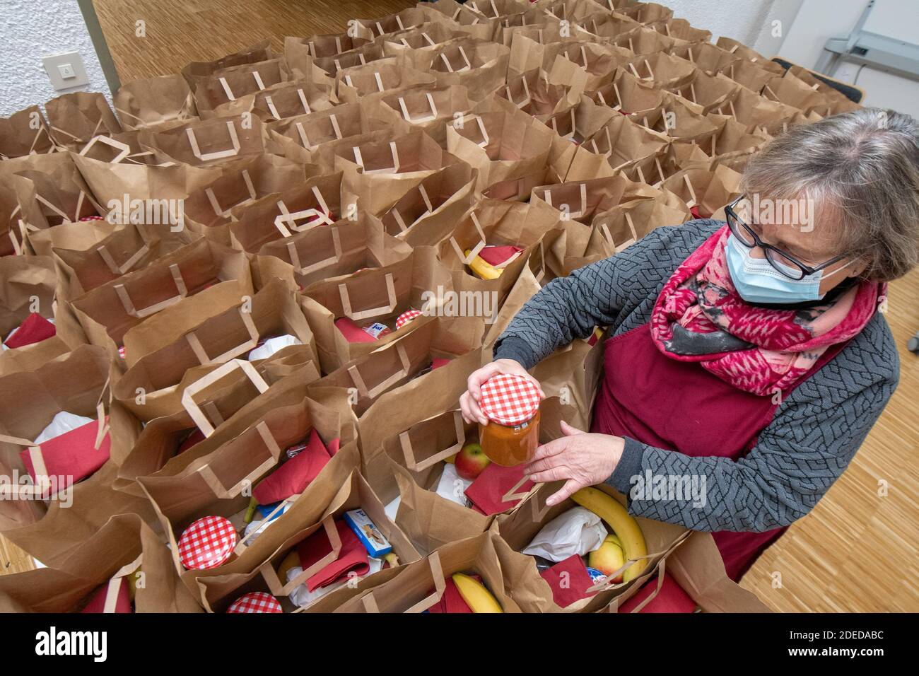 Ulm, Germania. 30 novembre 2020. Bertha Weimer prepara tini di carta con cibo. Come molte chiese vespri, la tavola ecumenica di Avvento di due parrocchie può offrire il pasto caritativo solo da togliere. Credit: Stefan Puchner/dpa/Alamy Live News Foto Stock