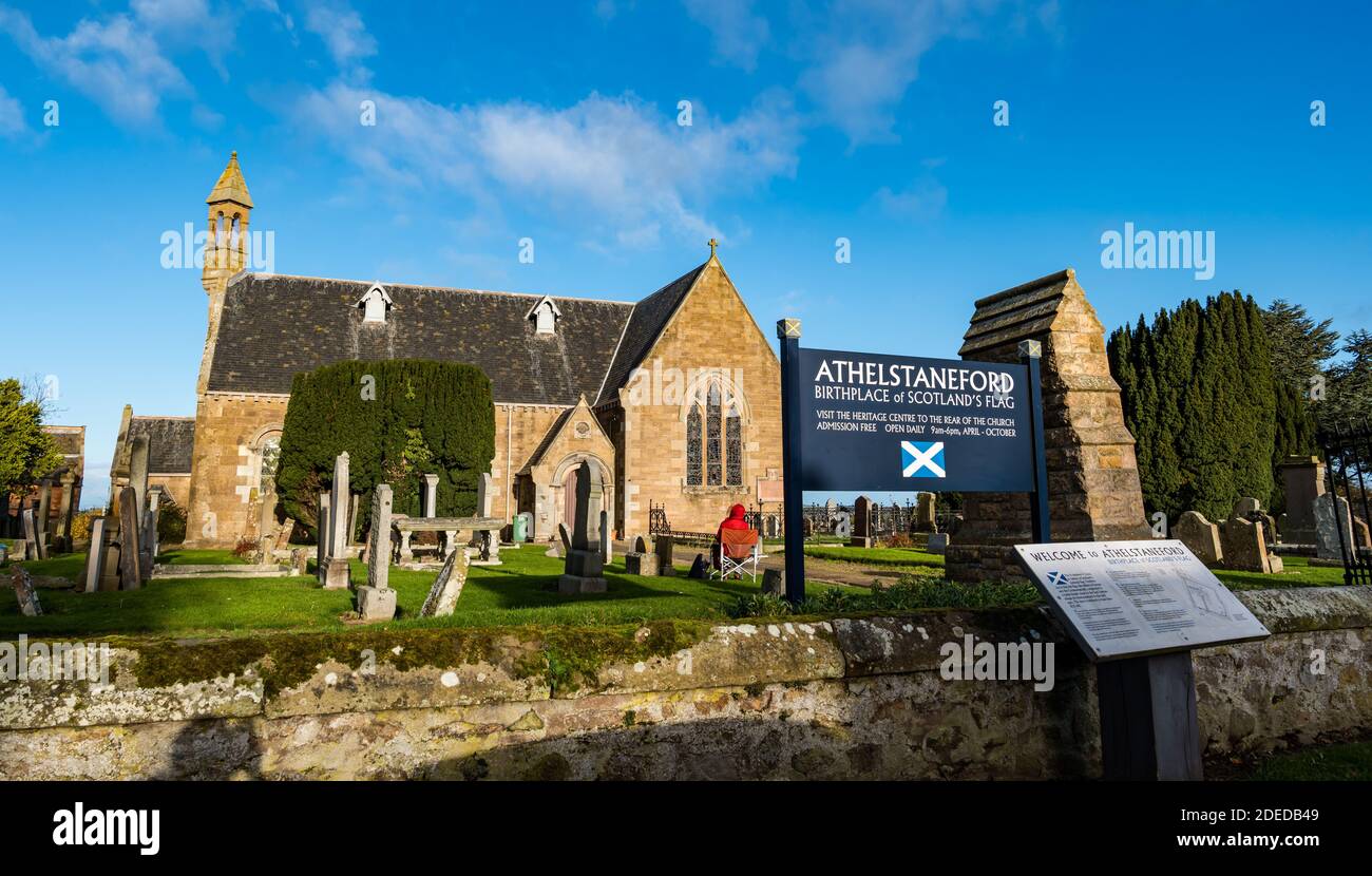 Athelstaneford, East Lothian, Scozia, Regno Unito, 30 novembre 2020. La chiesa parrocchiale in posizione del National Flag Heritage Centre con un'informazione sul sito storico del luogo di nascita della bandiera nazionale scozzese Foto Stock