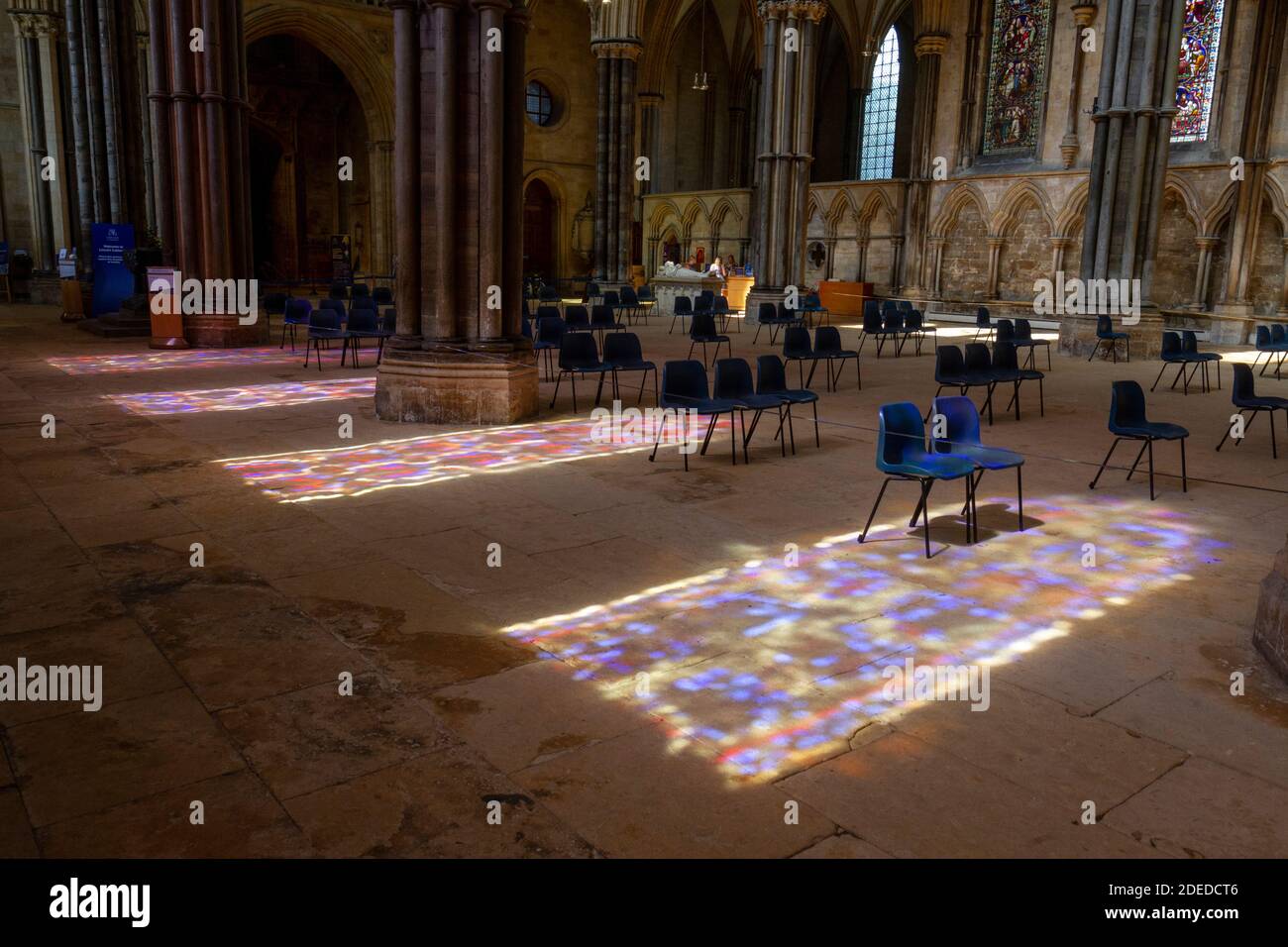 Finestra di vetro colorato con motivo illuminato sul pavimento in pietra all'interno della Cattedrale di Lincoln, Lincoln, Lincolnshire, Regno Unito. Foto Stock
