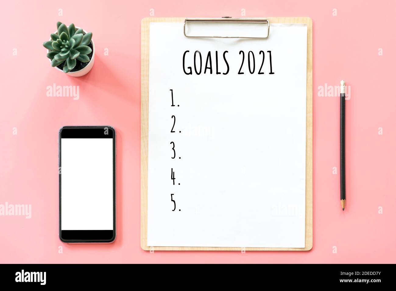 2021 concetto di anno nuovo. Elenco degli obiettivi in cancelleria, appunti vuoti, smartphone, pentola pianta su colore rosa pastello con spazio di copia Foto Stock