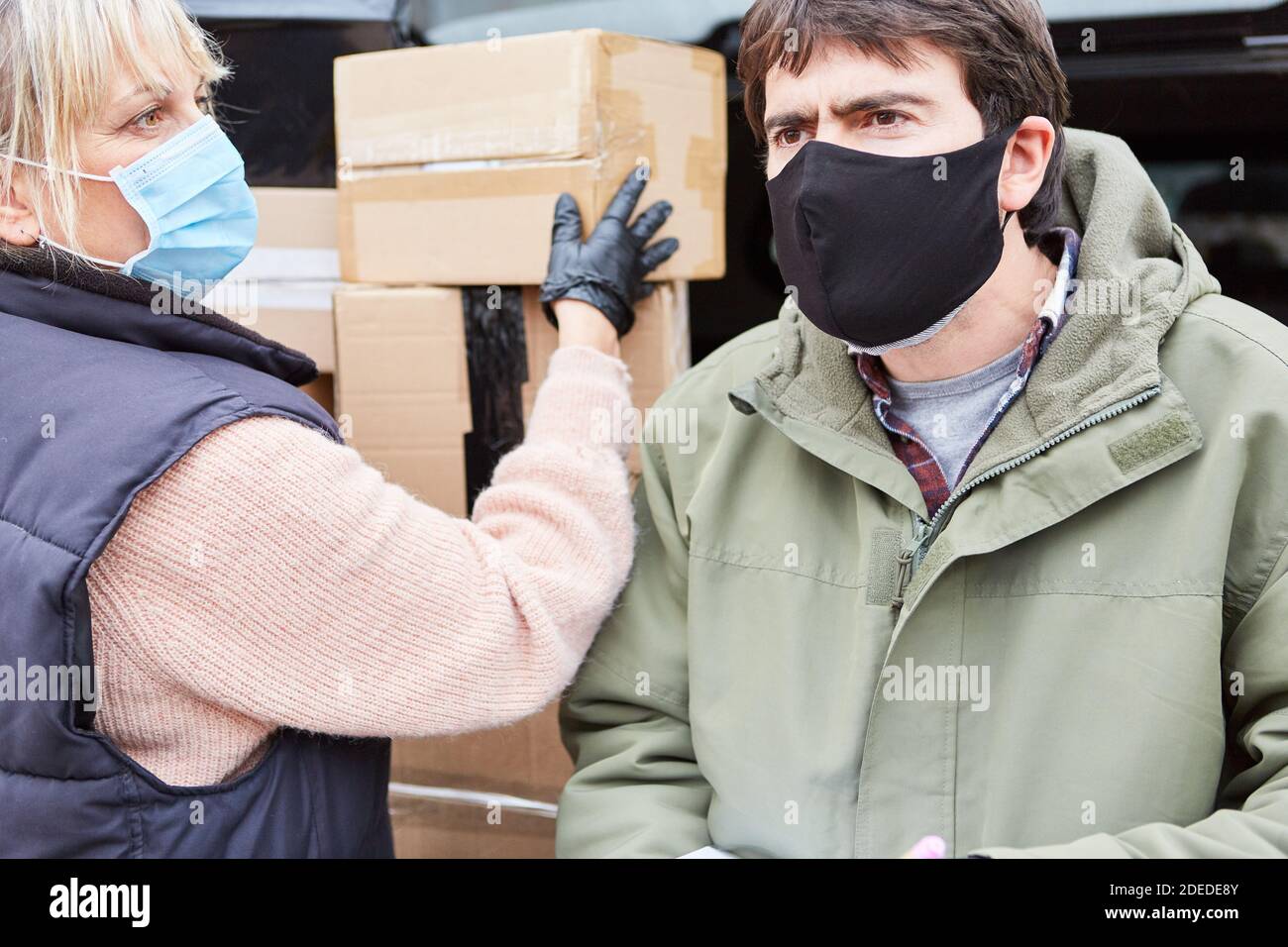 I consegnatori del pacco consegnano i pacchi a Natale con le maschere di faccia perché Di Covid-19 Foto Stock