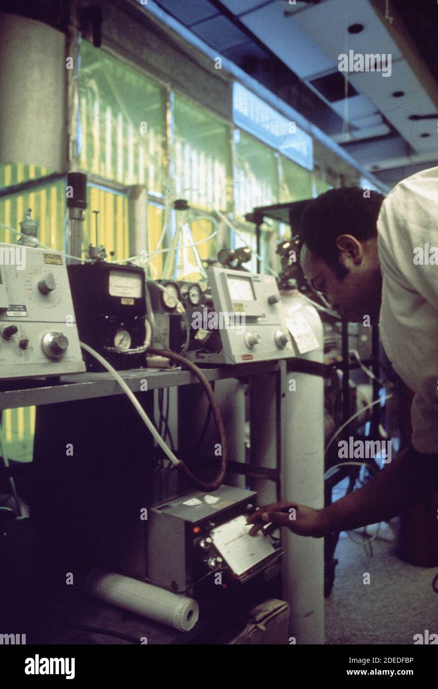 1970 Photos (1972) - Olin Moss; tecnico di strumenti per l'igienizzazione dell'aria che tara gli analizzatori di idrocarburi. Camera di produzione di smog sullo sfondo (Los Angeles California) Foto Stock