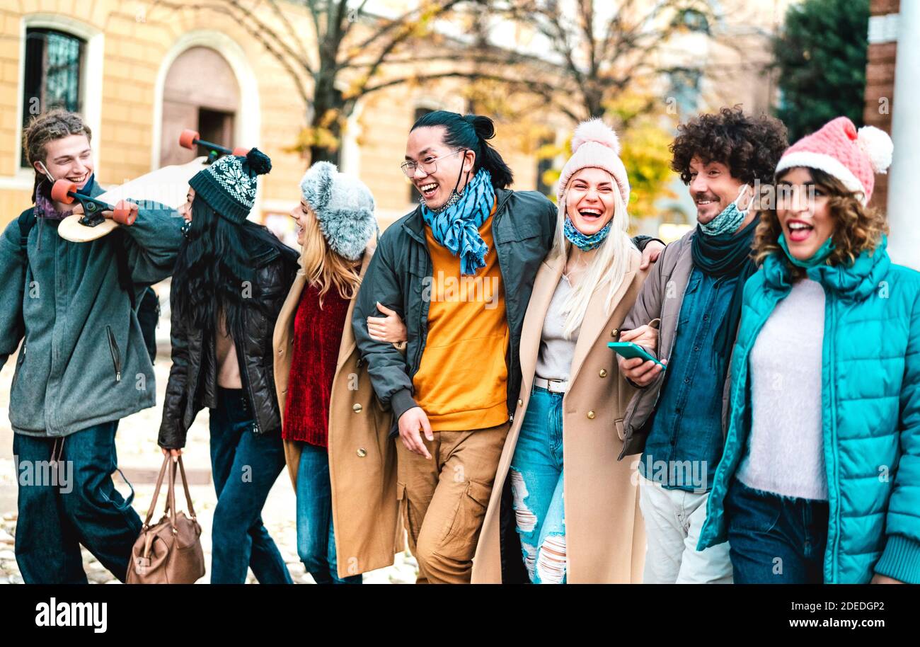 Le persone di Milenial camminano e si divertono insieme indossando il viso aperto Maschera alla città vecchia - nuovo concetto di stile di vita normale con amici multiculturali Foto Stock