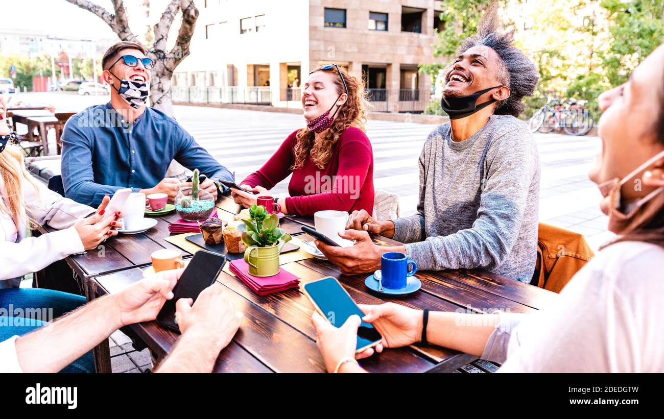 Persone che si divertono a bere latte all'esterno al caffè - giovane Amici che parlano insieme al ristorante caffetteria - nuovo stile di vita normale concetto Foto Stock