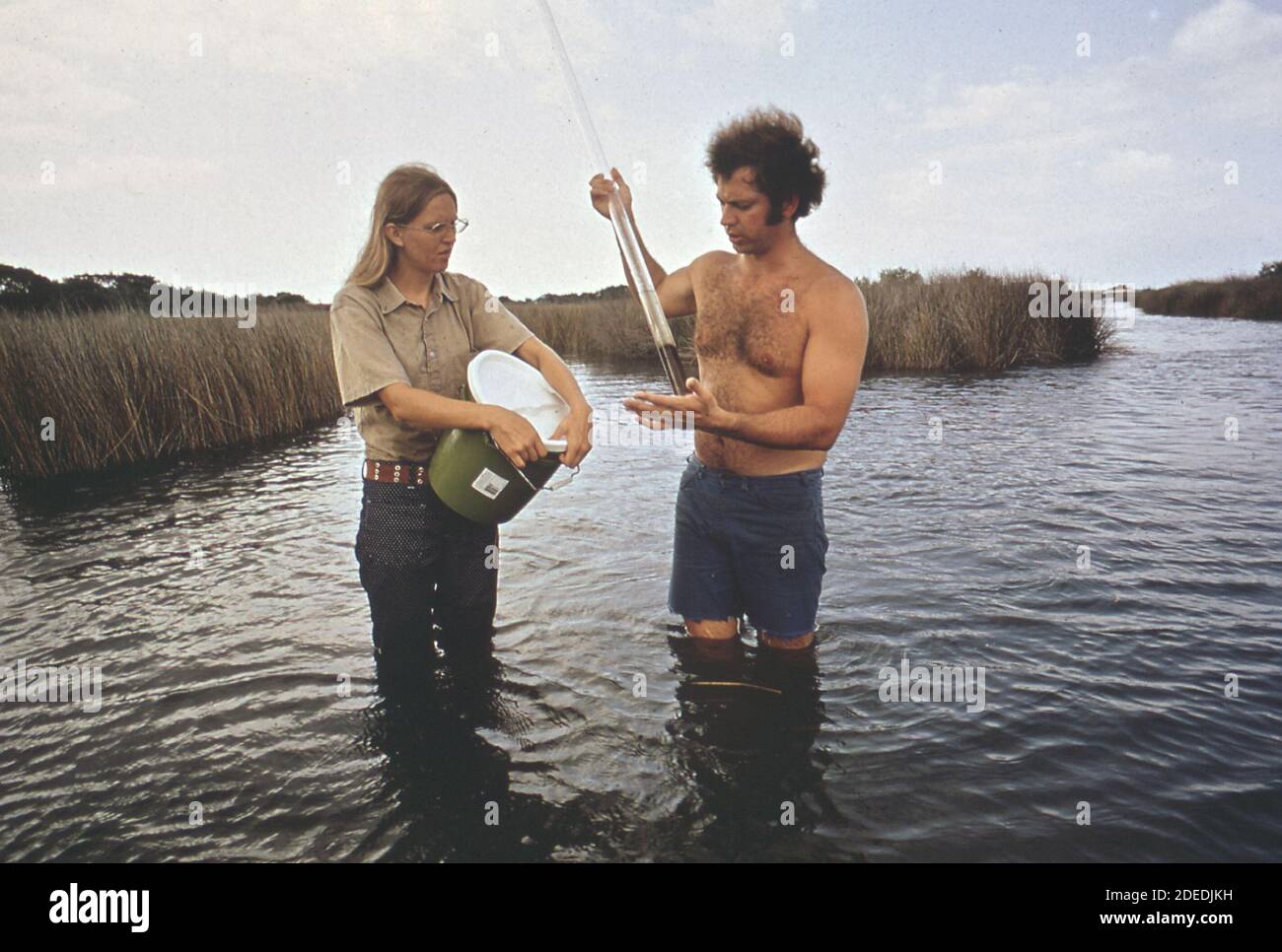 1970 Photo (1972) - EPA Gulf Breeze Laboratory biologi in un viaggio in campo a una palude di sale. Campioni di fango e sabbia dragati dal fondo di palude sono messi nel tubo di vetro Foto Stock