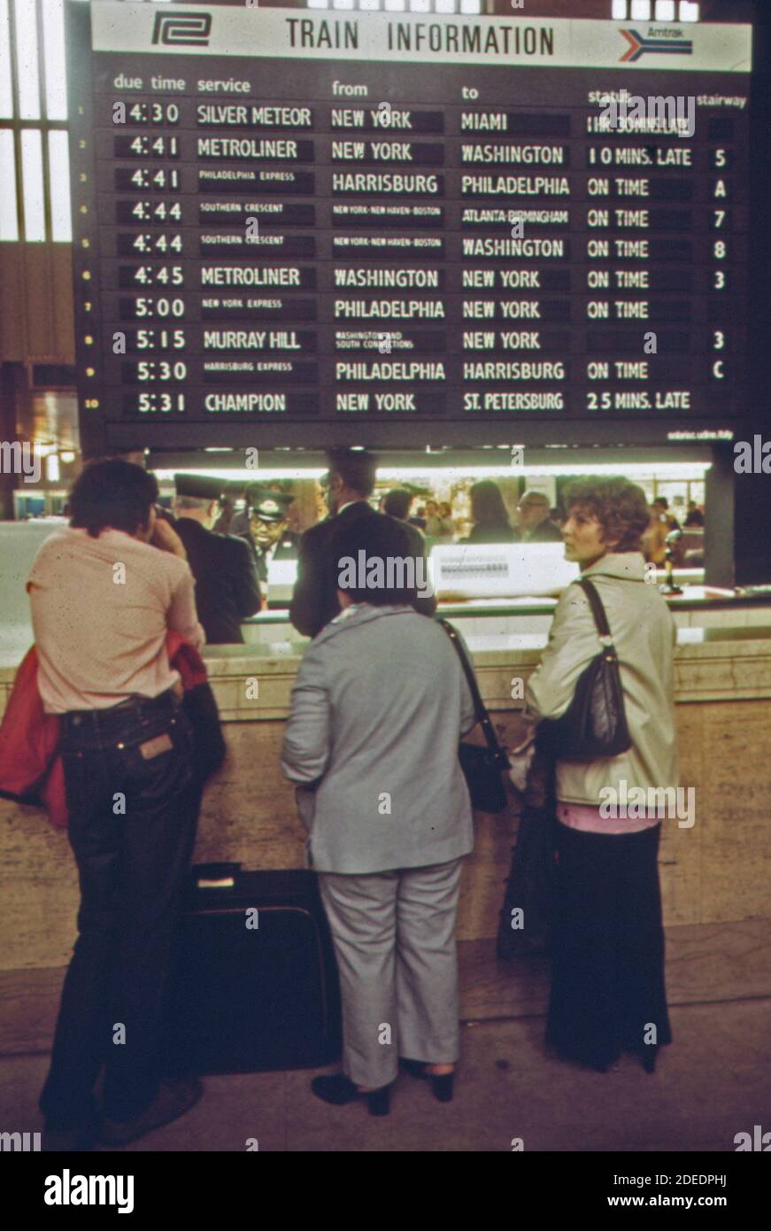 I passeggeri della Amtrak fermano per informazioni sui treni nella sala principale della stazione 30th Street di Philadelphia; Pennsylvania. CA. 1974 Foto Stock