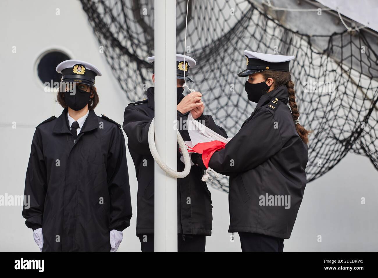 Studenti di marinai che elevano la bandiera della Polonia a Gdynia, Polonia settentrionale Foto Stock