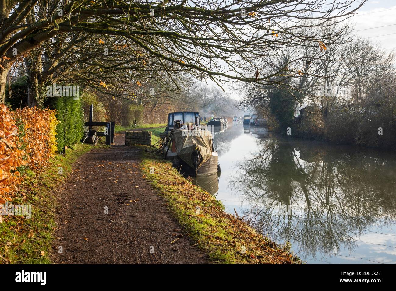 Le barche dei canali ormeggiate accanto all'alzaia nel tardo autunno sul canale Kennett e Avon in una mattinata invernale soleggiata, Bradford on Avon, Wiltshire, Regno Unito Foto Stock