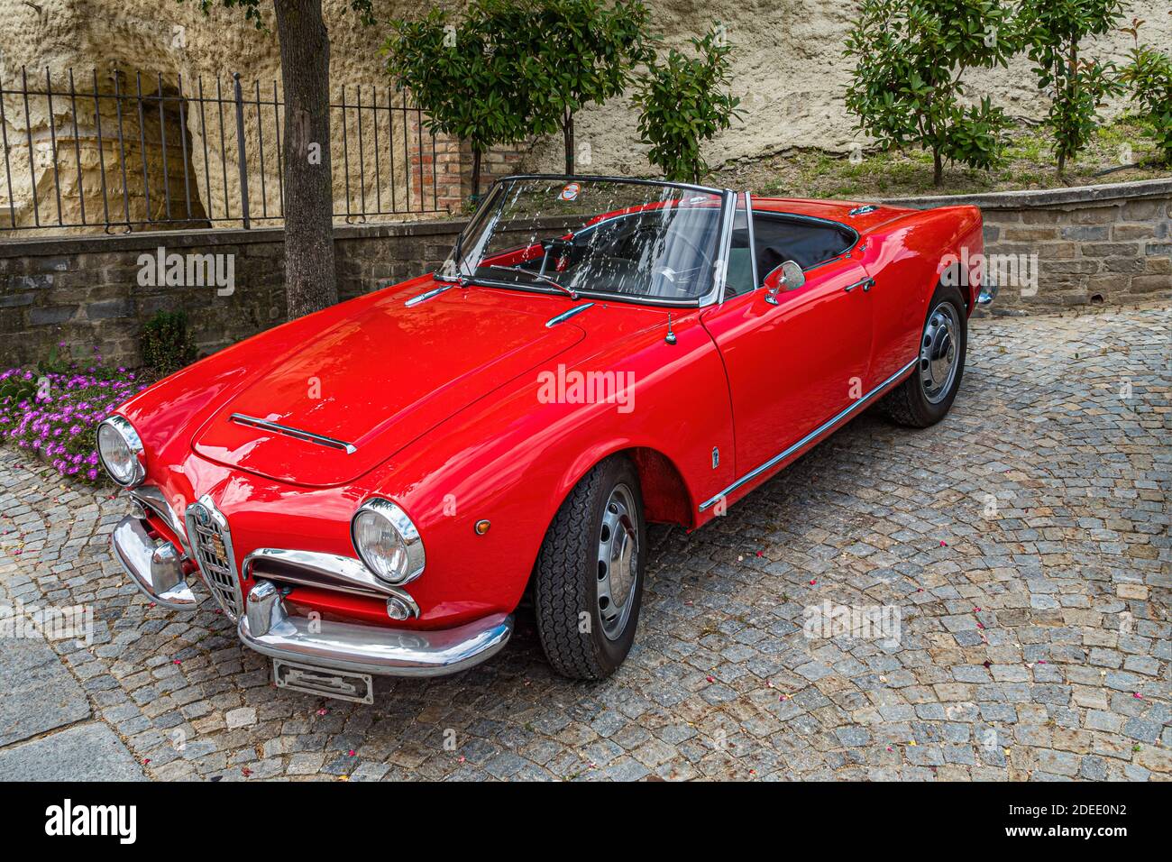 Diano, Piemonte, Italia - 18 giugno 2017: Parcheggio rosso Alpha Romeo Spider in una vecchia città italiana Foto Stock