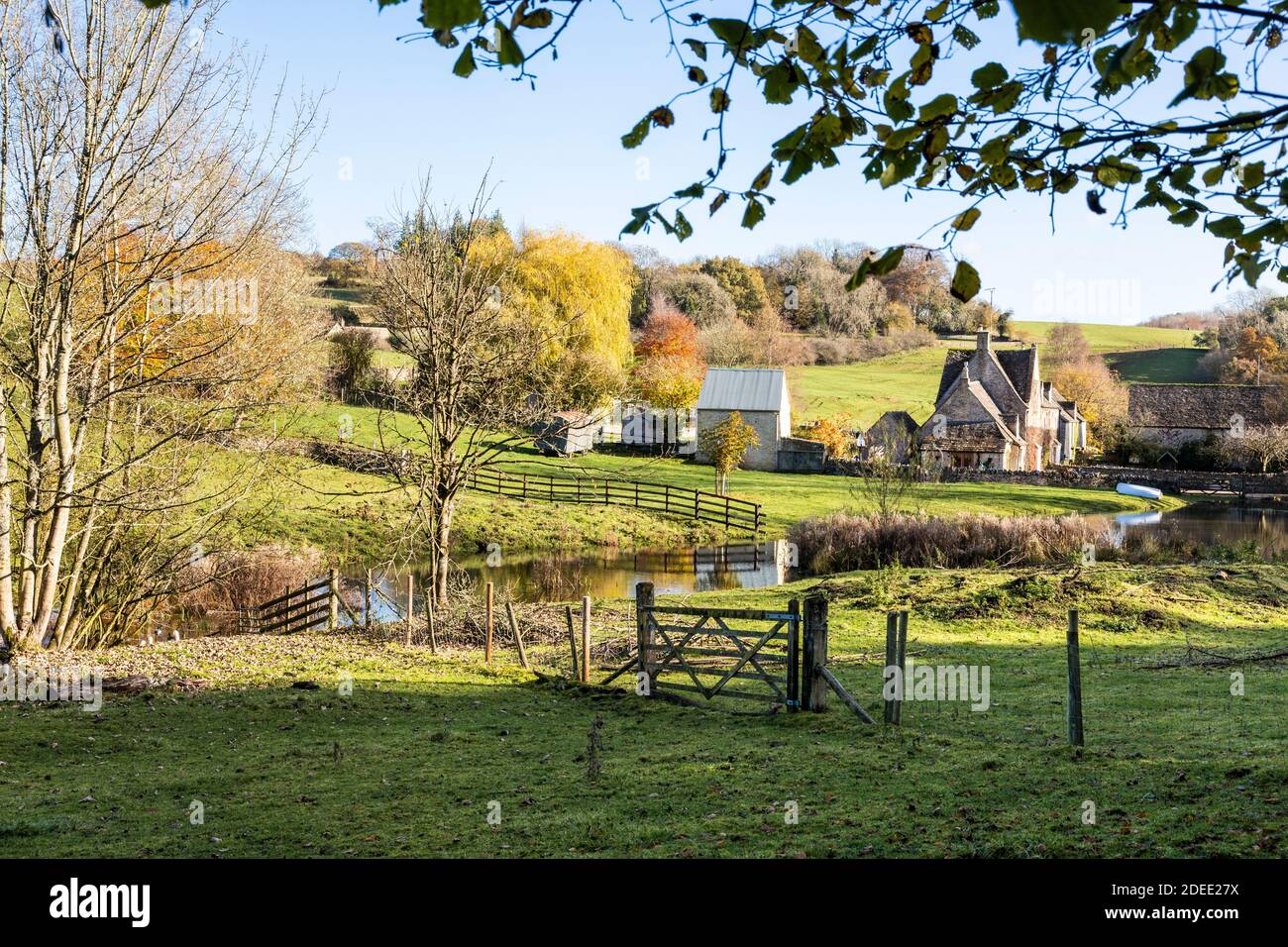 Autunno nel Cotswolds - il piccolo lago sul torrente dietro Manor Farm a Middle Dortisbourne, Gloucestershire UK Foto Stock
