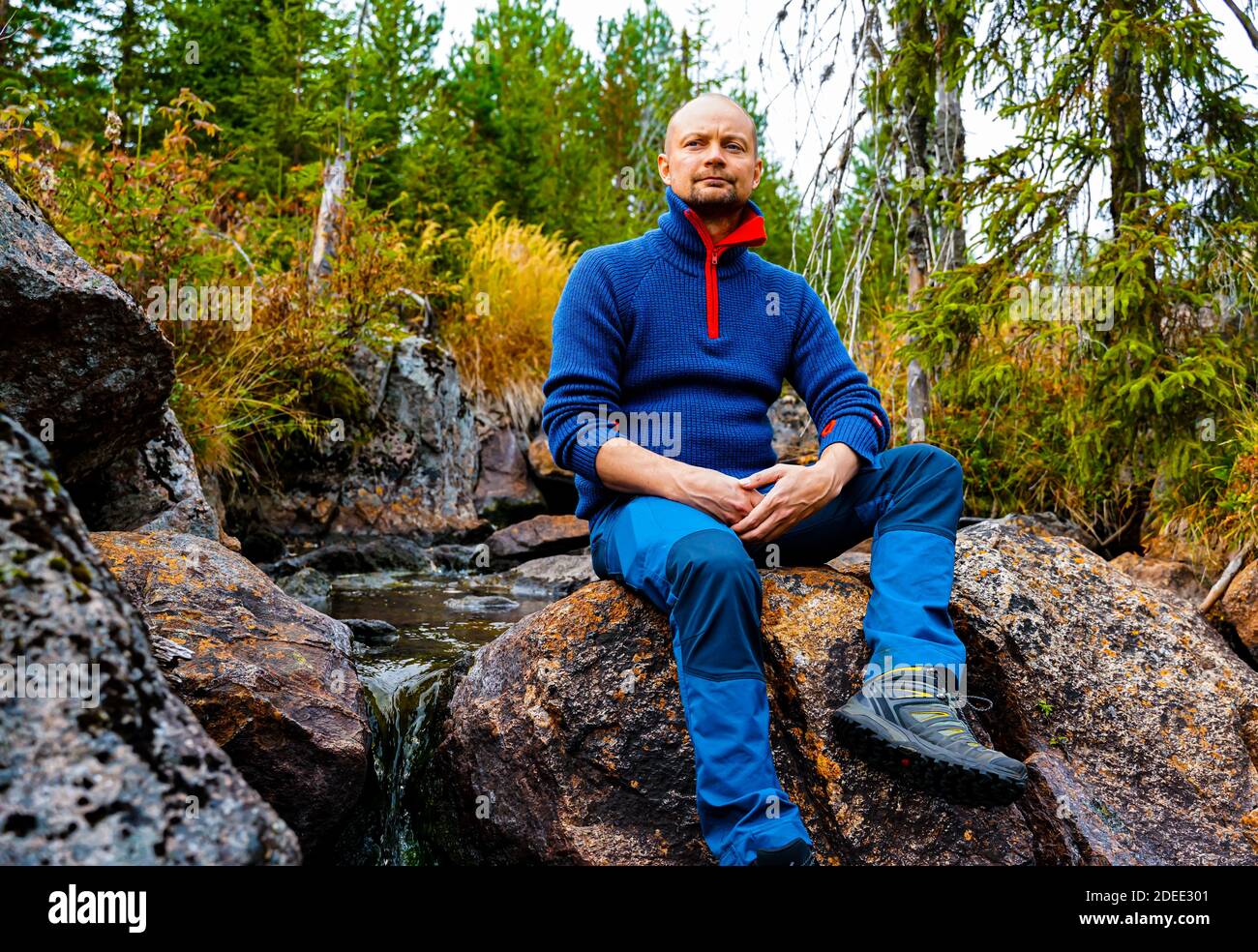 Escursionista che si riposa su una roccia in un ruscello. . Foto di alta qualità Foto Stock