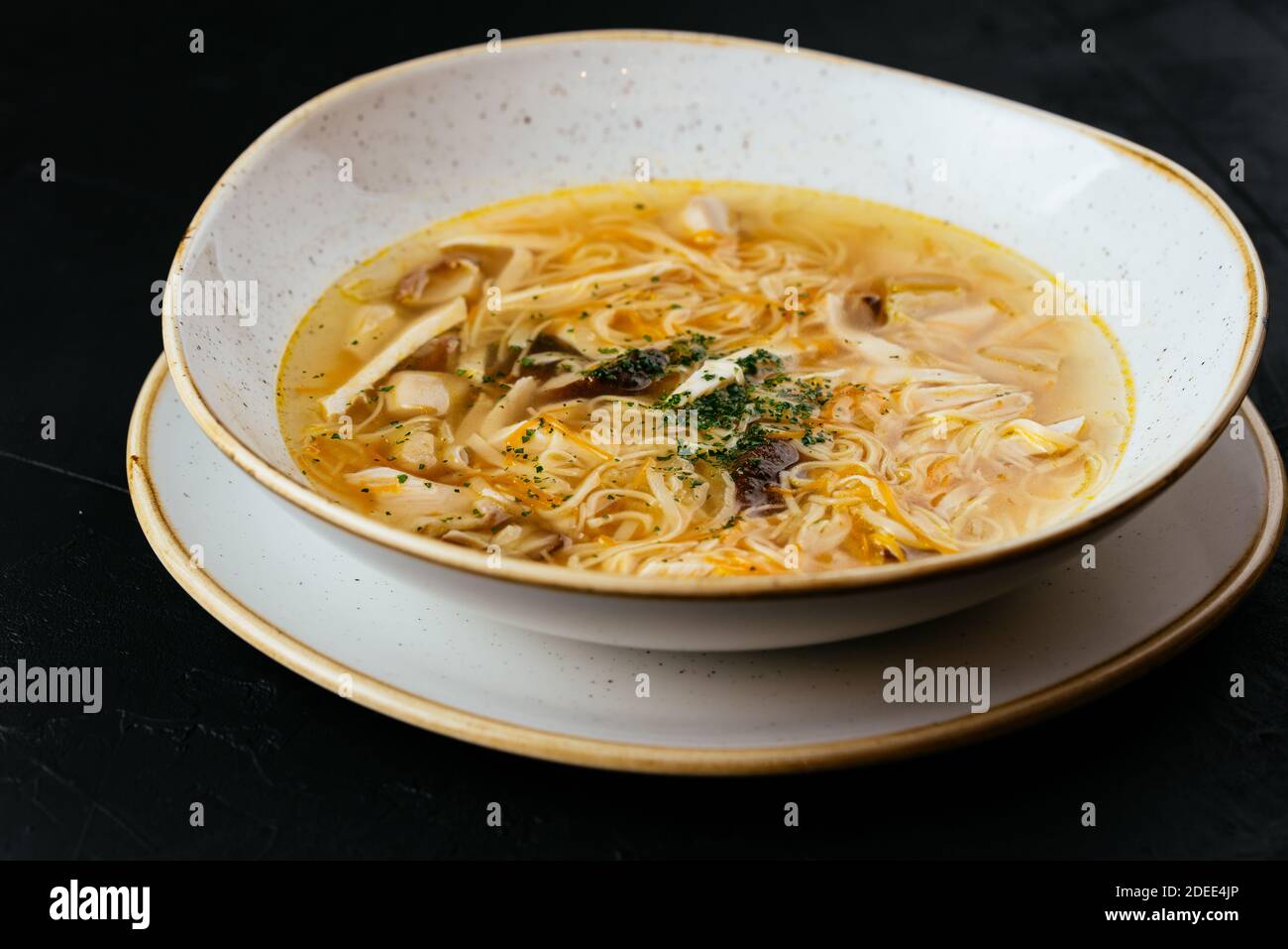 brodo di pollo con noodle su fondo nero testurizzato Foto Stock