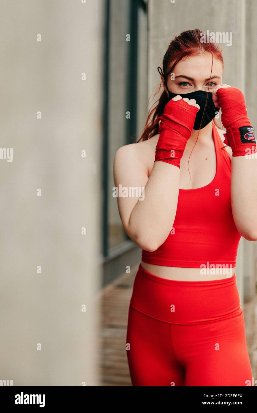 Boxer giovane femmina, allenarsi all'aperto a Brooklyn indossando maschera facciale. Foto Stock